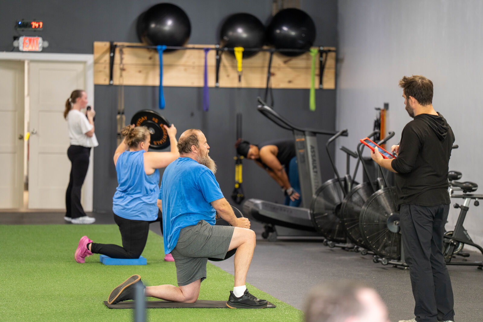 Coach guiding a semi-private group through lunges on the turf